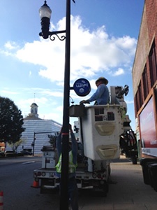 Lexington's Electric Department installing the lighted City WiFi medallions