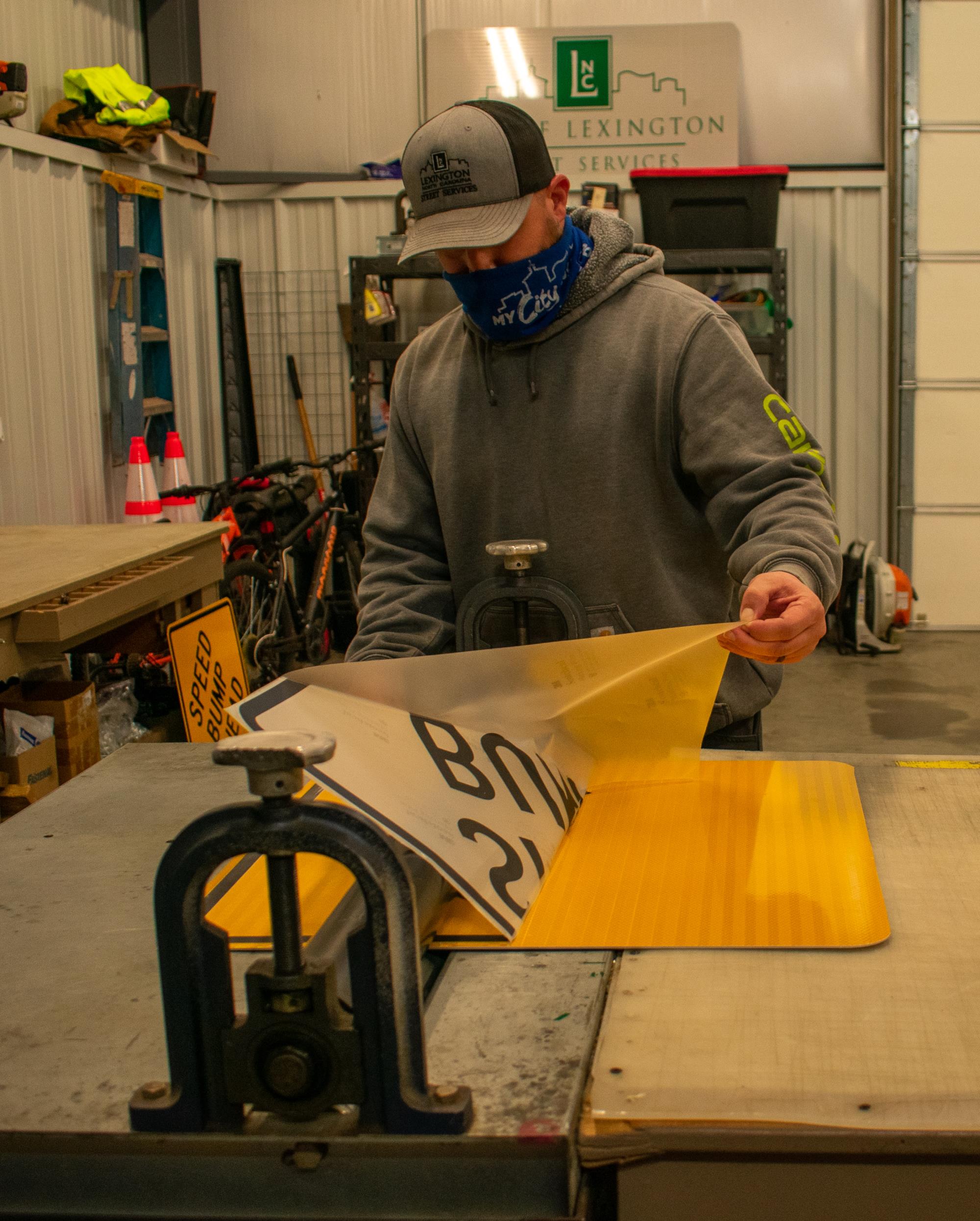 City employee working on speed bump sign