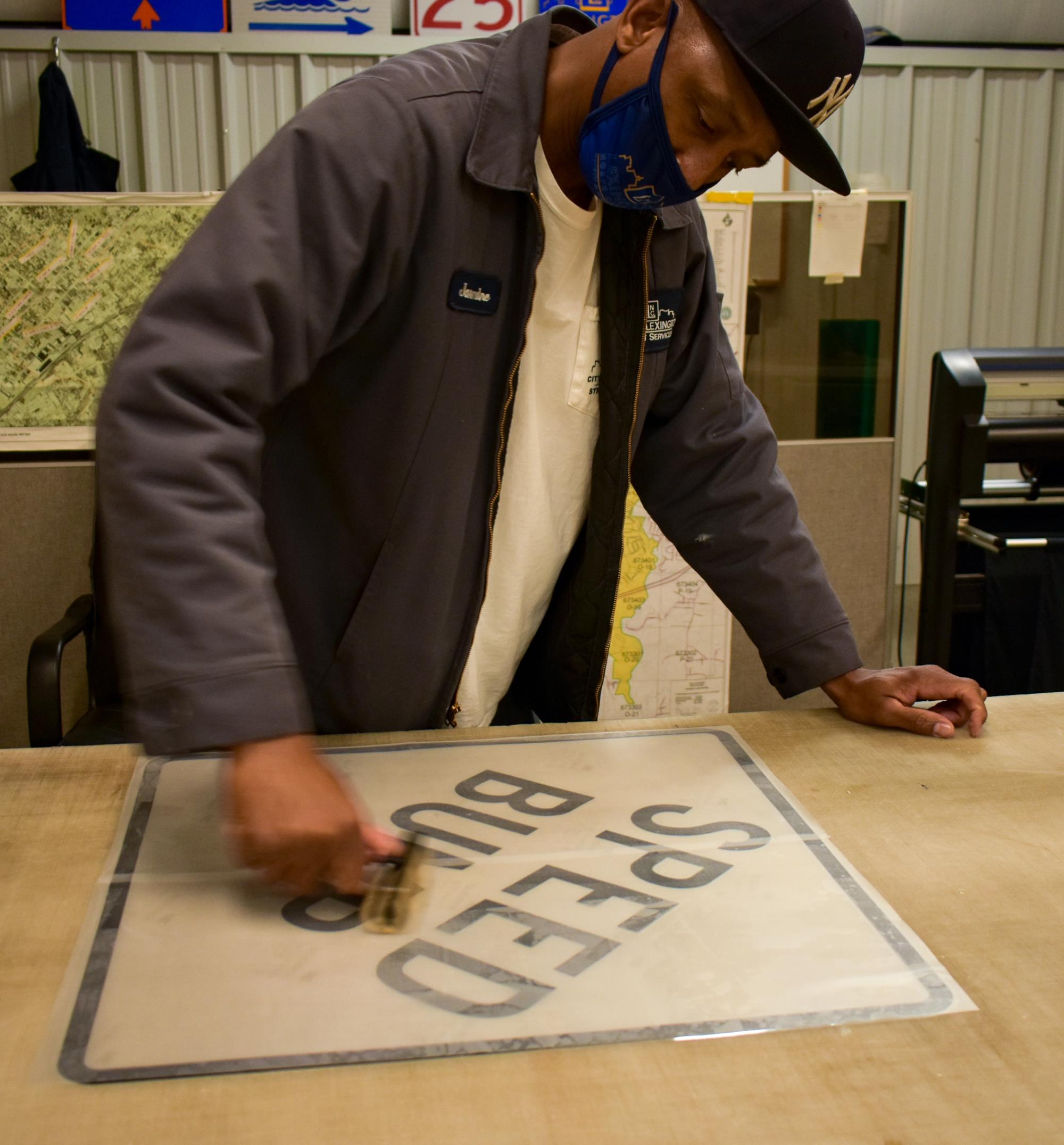 City employee working on speed bump sign