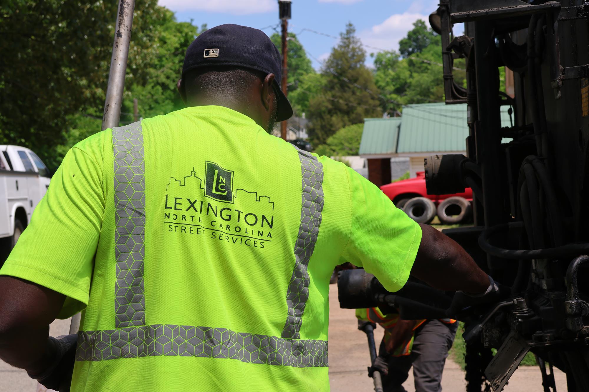 A streets employee wearing a lime green city of lexington vest